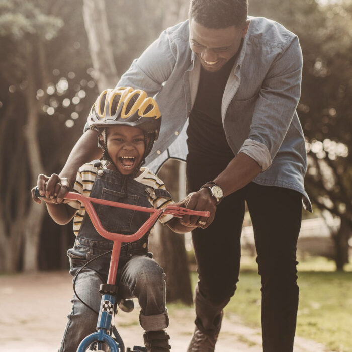 Dad teaching child to ride a bike